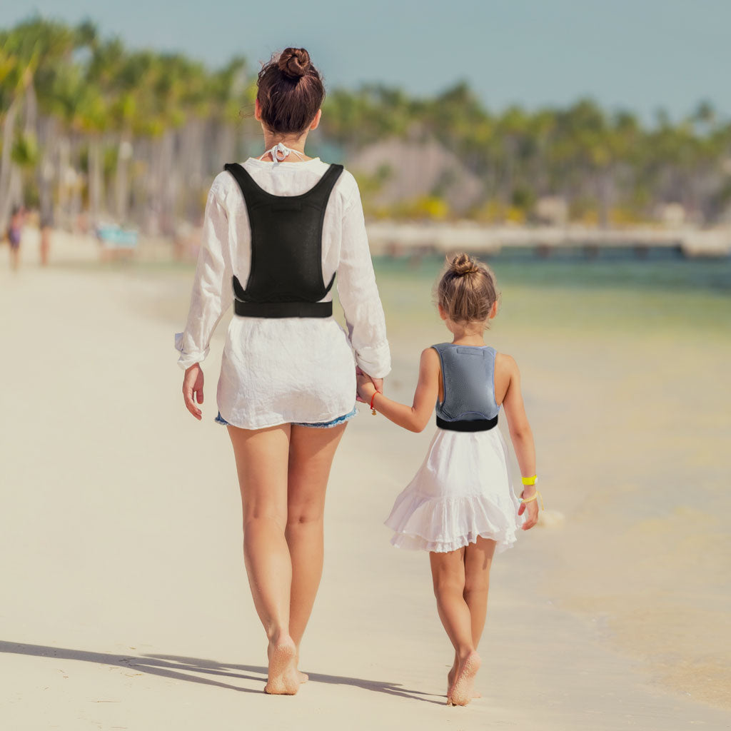 Women and child walking on a beach whilst both wearing cooling back supports